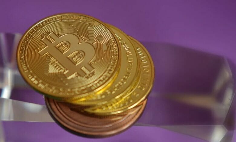 紫のテーブルにビットコインが積み重なる画像
